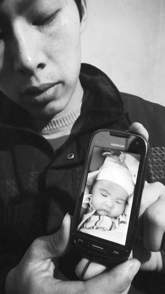 小柯翻出手机中孩子生前的照片。 小柯翻出手机中孩子生前的照片。